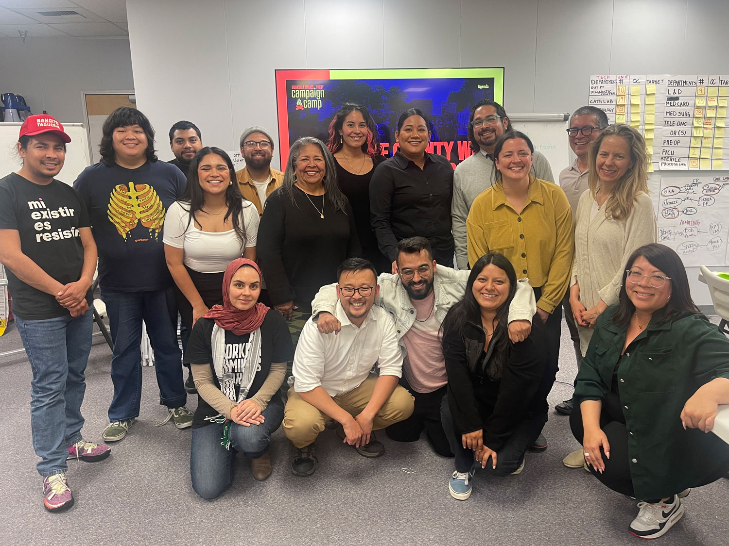 A group of diverse people standing in tiers, smiling and being merry.